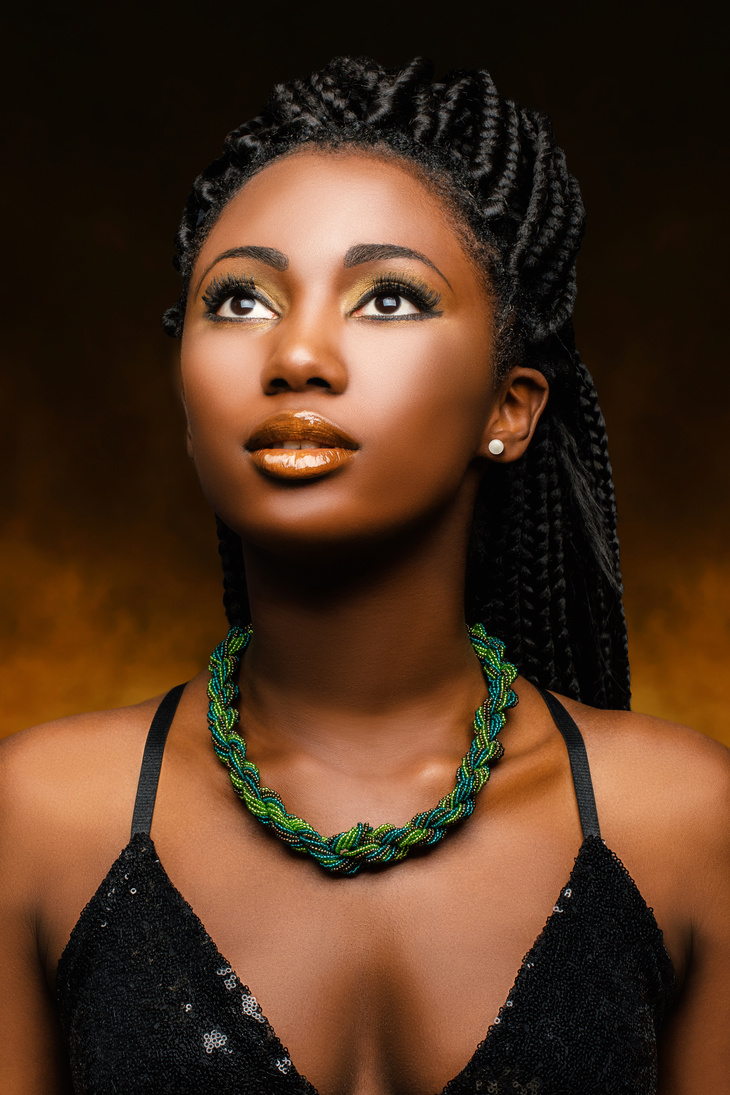 Stunning black woman with braids looking up.